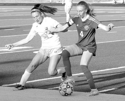 Goddard sophomore midfielder Emmy Hedden, right, battles a Maize South player during last Thursday’s home game. Hedden has become a key leader for the Lions. She returned to action after being sidelined for three games by an injury. Travis Mounts/TSnews