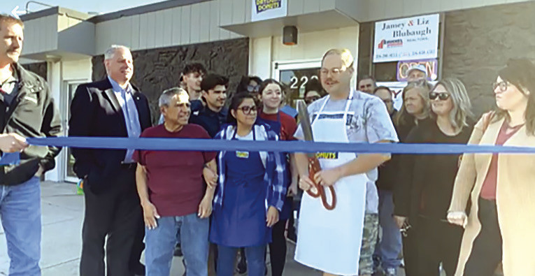 Mr. B's Daylight Donuts was officially welcomed to Goddard last week with a Tuesday morning ribbon cutting downtown. Co-owner Jamey Blubaugh gets ready to cut the ribbon at the ceremony. The business opened in March. Contributed photo