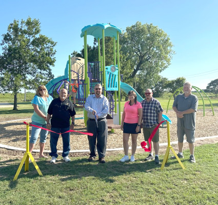 Haysville Mayor Russ Kessler cuts the ribbon at Plagens-Carpenter Park during Monday evening’s ribbon-cutting ceremony. The city remodeled the playground equipment, which is located in the southeast corner of the park. City of Haysville/Contributed photo
