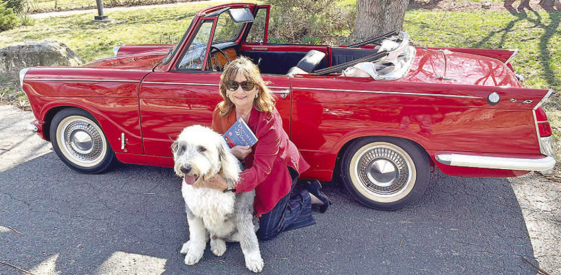 Author Susan Armstrong is pictured with her red convertible and her dog. Armstrong bears some similarities to Josie Posey, the central character in her debut novel, “Doomed by Blooms.” Armstrong is now writing the second of five books in the series. Contributed photo