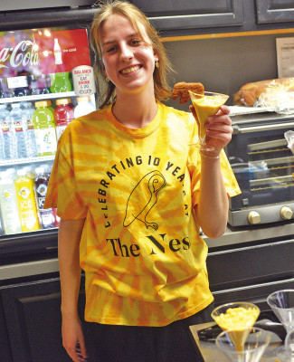 Garden Plain High School sophomore Ryann Meyer shows off The Nest’s macaroni-and-cheese with a chicken nugget treat, featured at last week’s 10th anniversary party. Dale Stelz/TSnews