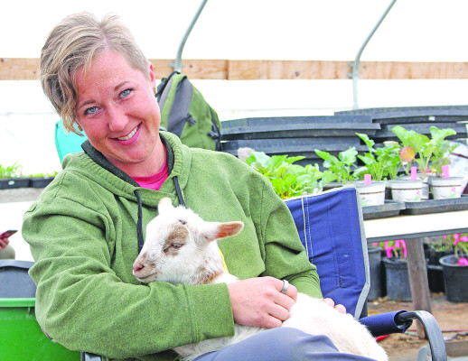 Shelby Beyer of Cheney has worked with her family to start Anchor Farm, located just outside of town. She follows regenerative agriculture principles in her operation, which recently started offering produce for sale in Cheney. Here, she is holding a goat from Jako Farm near Yoder. She sells produce there and works for the farm part-time. She has been caring for the goat, which needs to be bottle-fed. Travis Mounts/TSnews