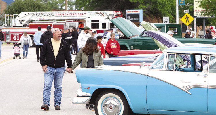 RIGHT: Overnight rain and a chilly day did not deter a nice crowd from attending Saturday’s Cheney Fire Department car show. In addition to a car show, there was a corn hole tournament, a ribbon cutting and lunch, plus children’s games as part of Celebrate Cheney, sponsored by the Cheney Chamber of Commerce. LEFT: Layke Hammann and Tina Kichler check out one of the dozens of cars entered in the car show. Travis Mounts/TSnews
