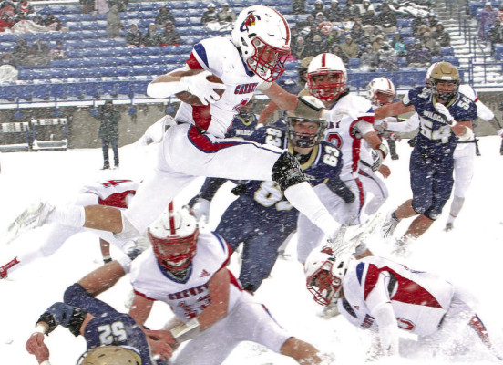 Drew Tolar leaps over a pile of players at the start of an 88-yard kickoff return for a touchdown. The play gave Cheney a 13-7 lead over the Hayden Wildcats. Cheney went on to win the 3A State title game 34-7. Travis Mounts/TSnews