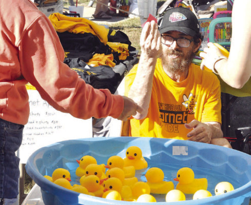 With nearly perfect weather, the Haysville Fall Festival drew large crowds for last weekend’s event. ABOVE: Mike Diedrich helps with the Haysville Hornets Special Olympics booth at the Fall Festival. ABOVE LEFT: Scarlette Forrest shows off her parade candy to her mother. BELOW LEFT: Robert Ingram of Wichita polishes his 1996 GMC pickup during the car show at the Haysville Fall Festival. Ingram, who works in Haysville, is a member of the ICT Truck Club. Paul Rhodes/TSnews