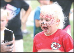 Brodie Janzen reacts to the face painting he received from Tori Evans at the Cardinals 4-H Club booth. Travis Mounts/TSnews