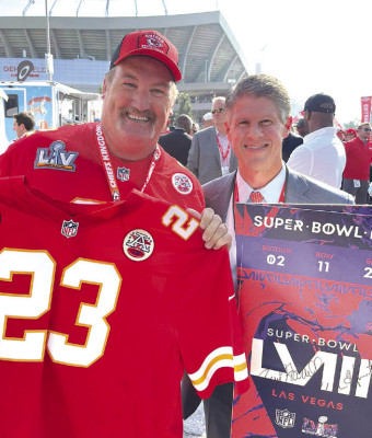 Kansas City Chiefs owner Clark Hunt holds Kelly Kennedy’s tickets for the next Super Bowl. The tickets were signed by Hunt, pictured with Kennedy, and by National Football League commissioner Roger Goodell. Contributed photo