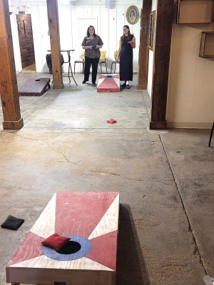 Danielle Gabor, left, and Kailyn Hogan play corn hole during the Haysville Chamber of Commerce mixer held last Thursday at Blood Orchard Brewing Co. Gabor and Hogan both work for the City of Haysville, and had a heated game going on with other City Hall staff members. The Chamber mixers are designed to give members opportunities to meet up, other than at regular Chamber lunch meetings. Paul Rhodes/TSnews