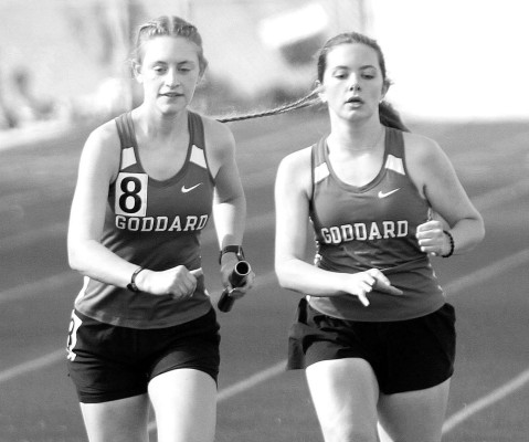 Goddard’s Olivia Brownell, left, takes the batton from Emory Hickey for the last leg of the 4x800-meter relay at the Lions home track and field meet last Thursday. Travis Mounts/TSnews