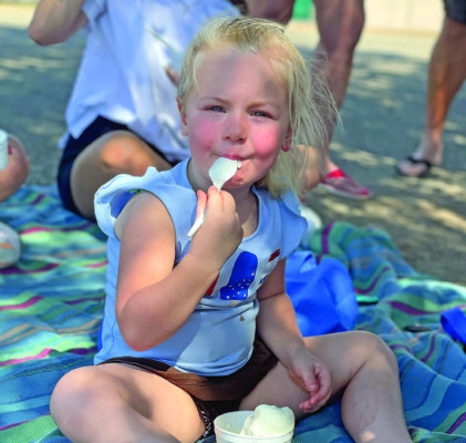 ABOVE: Chloie Hilger enjoys a cup of ice cream during the Argonia Days celebration on Saturday. The annual event took place downtown. BELOW: Children react to emergency vehicles at the beginning of Saturday morning’s Argonia Days parade. Travis Mounts/TSnews