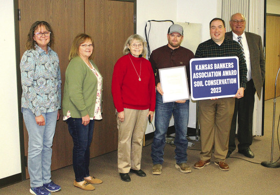 Farm operator Bryce Allen, third from right, and members of the Stocking family receive a Bankers Association Award from banker representative Phil White, second from right, and Sumner County Conservation District chair Doug Hisken.