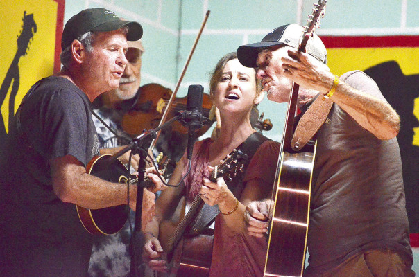 Area musicians who are part of the band Dear Friends perform on Stage 5 at the Walnut Valley Festival in Winfield this past week. Pictured are Brad Bennett, left, and Dave Prilliman, right, both of Conway Springs, and Lindsey McLemore of Clearwater. The band also performed this month as part of the Heritage Square concert series in Wichita. Paul Rhodes/TSnews