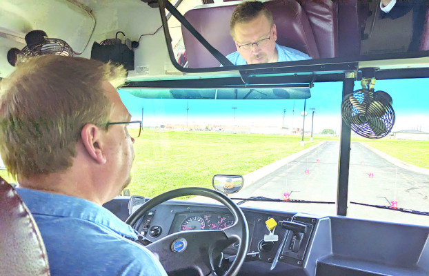TSnews managing editor Travis Mounts takes a turn driving a school bus at Goddard Public Schools’ recent job fair. School districts like Goddard will provide training and help drivers earn a CDL (commercial driver’s license). Dana Baxa/Goddard Public Schools
