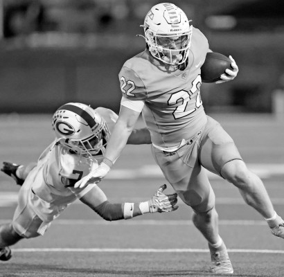 Eisenhower runner Izaac Popp tries to slip out of a tackle by Goddard defender Cooper Glasscock. The Tigers took an early lead, but then had to fight off a good comeback effort by the Lions during last Friday’s rivalry game in Goddard. Matt Bucher/TSnews
