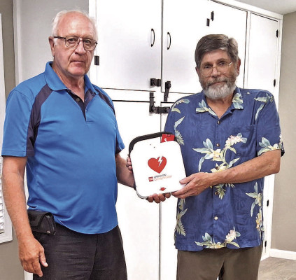 Dennis Long, right, presents a new AED to Cheney Senior Center vice president Steve Garton. The donation was made at the center’s August potluck. Contributed photo