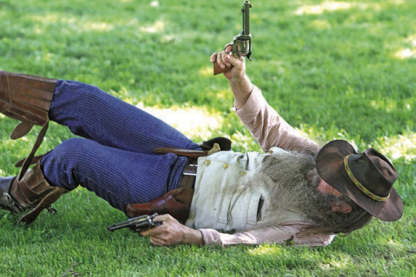 ABOVE: A would-be robber falls to the ground following a shoot-out. The shootout was staged by re-enactors from the Old Cowtown Museum, and was presented as part of this year’s Vintage Market in Haysville. The Vintage Market is held each June in conjunction with the Haysville Hometown Market, which takes place each Saturday in the summer and early fall. This year marks 25 years of the market. BELOW: Siblings Sophie and Luke Davis, front right, pose with the Old Cowtown re-enactors. Travis Mounts/TSnews