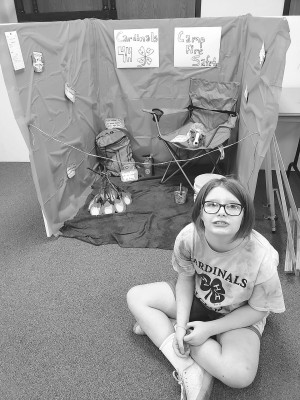 Allie Harlan sits with the Conway Springs Cardinals' booth entry. Contributed photos