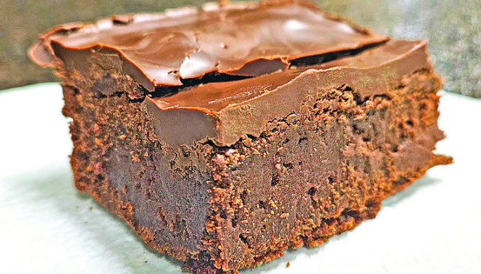 These chocolate ganache gooey brownies feature a thick, chocolate topping with a hint of peanut butter, on top of dark-chocolate-laden cake-y brownies to provide a sinfully decadent dessert.