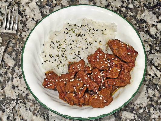 Caramelized pork with rice is slow-cooked on the stove top, along with onions and plenty of Asian-inspired seasonings to make a hearty dinner, along with plenty of leftovers.