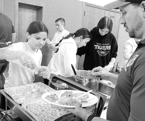 An Eisenhower Middle School student and member of the EMS student council helps serve Thanksgiving lunch during last week's Goddard Community Thanksgiving dinner. The event always draws a large crowd plus additional people who get meals to go. The dinner is a long-running Goddard tradition, organized by the Goddard Lions Club. Travis Mounts/TSnews