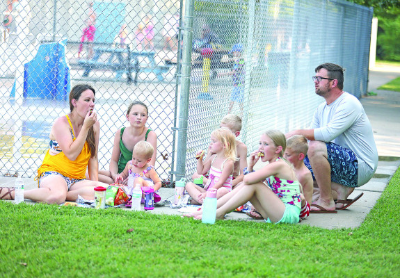 The Bradshaw family enjoys a hot dog dinner at National Night Out, held Aug. 5 at the Dewey Gunzelman Memorial Swimming Pool in Haysville. The annual event, held in communities across the country, promotes relationships between neighborhoods and between police and the communities they serve. Stephanie McKennon/TSnews