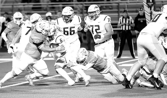 Eisenhower defenders Travis Nicholson (99) and Isaiah Martin (41) bring down a Hays runner during the Tigers’ home playoff victory last week. This Friday, Eisenhower will host the Maize Eagles. Matt Bucher/Contributed photo