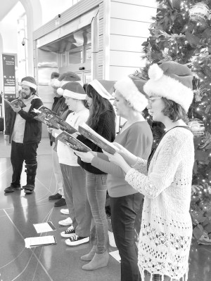 Members of the Wichita Grand Opera Caroling Caravan sing at Wichita's Eisenhower International Airport as a send-off for publisher Paul Rhodes' group of holiday travelers. Paul Rhodes/TSnews