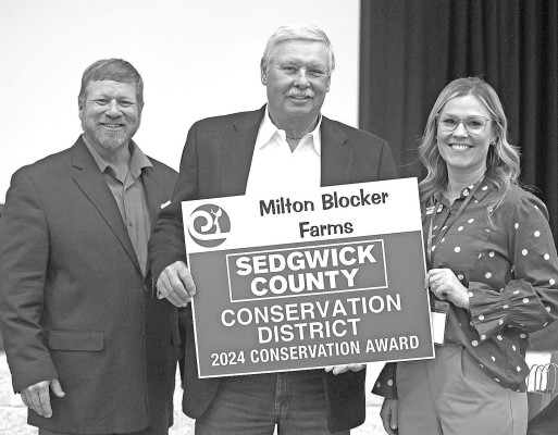 John Blocker, center, accepts the 2024 Conservation Award on behalf of his late father, Milton Blocker. The elder Blocker died last October at age 98. Stephanie McKennon/ TSnews