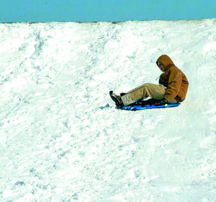 A youth slides down the Lake Afton dam on a snow day. The first two months of 2025 have brought multiple rounds of snow and ice, along with dangerous cold, and that has led to multiple days of school being canceled. File photo