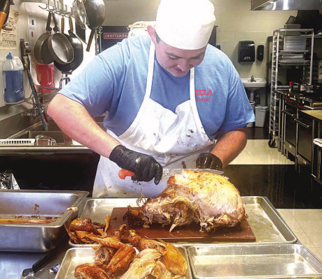 Campus High culinary student Connor Pedrow slices a turkey during The Gallop’s Thanksgiving meal prepared for IB students. Pedrow and Cerina Brandt were the executive chefs. Contributed photo