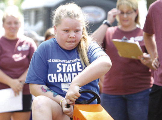 ABOVE: Ava Clouse pedals to a win in the Age 10 division of the Sedgwick County Fair Pedal Pull, sponsored by Sedgwick County Electric Cooperative. She was a Kansas State Fair champion last year, and advanced to the national pedal competition at the Corn Palace in Mitchell, S.D. BELOW: Quinton Logsdon gives all he has during the Pedal Pull. He won the Age 8 division, and earned the right to compete at the Kansas State Fair. Travis Mounts/TSnews
