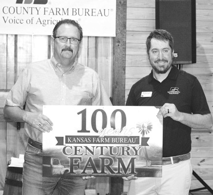 Randy Woods is presented a sign for the Century Farm owned by him and his wife, Carol, and his mother, Deanna. A Century Farm is a farm or ranch in the United States (or Canada) that has been officially recognized by a regional program, such as Kansas Farm Bureau, documenting the farm has been continuously owned by a single family for 100 years or more. Travis Mounts/TSnews