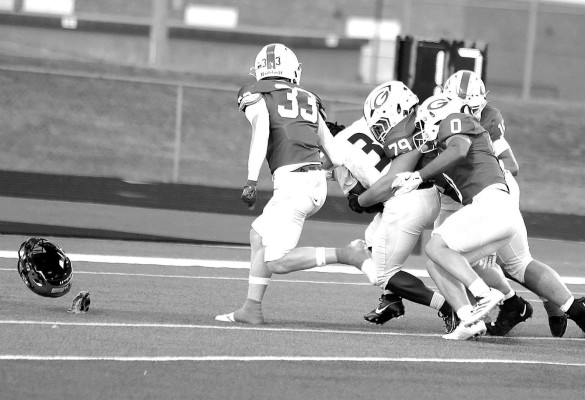 With an opponent’s helmet flying, a group of Goddard Lions tacklers brings down an Andover Central Jaguar for a first-quarter safety during the Lions’ homecoming victory. The safety gave the Lions a 2-0 lead. Stephanie McKennon/TSnews
