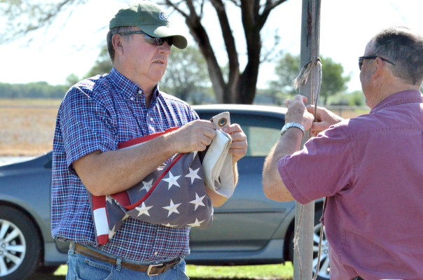 Paul Rhodes/TSnews Brothers Don, left, and Jim Seiwert, right, work together to raise the flag during Monday's Memorial Day service at Viola Cemetery.