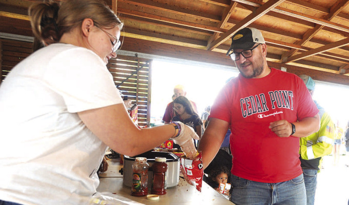 A volunteer tops off a walking taco during National Night Out in Goddard. See more photos online at tsnews.com. Dale Stelz/TSnews