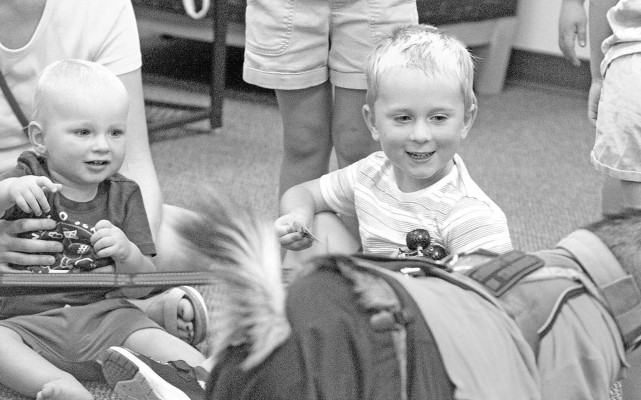Peter and Marcus Heinicke of Clearwater enjoy seeing a goat at the Clearwater Public Library on July 29. Ranger, a goat in training, visited for a reading-toa- goat event. Ranger is part of the Rosie's Snuggle Bunnies non-profit, based in Clearwater. Travis Mounts/TSnews