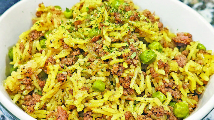 One-pan beef, rice and peas is a simple dish that packs tons of flavor, with delicious caramelized onions, turmeric and other spices, along with fresh parsley to brighten the dish.