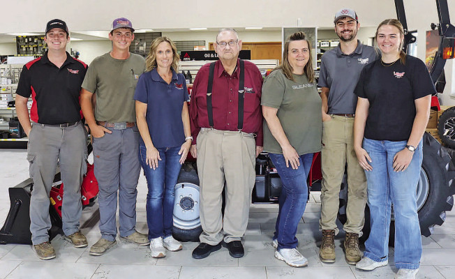 From left, Cody Gorges, Brady Gorges, Wendy Gorges, owner/manager Leroy Schmidt, service manager Nancy White, Brandon White and Jordan White of Schmidt &amp; Sons, stand in front of a Massey Ferguson 1E-40 tractor at their showroom. The business will celebrate its 60th anniversary next week. It is located at the corner of Rayl Road and Silver Lake Road, west of Andale. Michael Glenn/Hutchinson Tribune