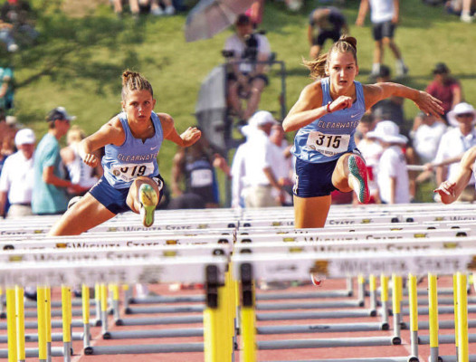 Clearwater’s Madison Williams, left, and Kenzy McArtor run side by side during Saturday’s 100-meter hurdles final in the Class 4A State track meet at Wichita State University. Williams and McArtor finished first and second, respectively, and they had the same result in the 300-meter hurdles. Williams is a three-time champion in the races. For a second straight year, McArtor finished in second place behind her teammate in both races. Makayla Wassenberg/MLW Photography