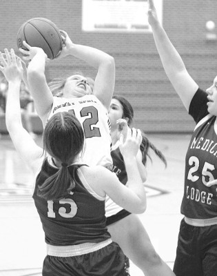 Brooke Beck tries to shoot over a pair of Medicine Lodge defenders during Friday’s home game. Travis Mounts/TSnews