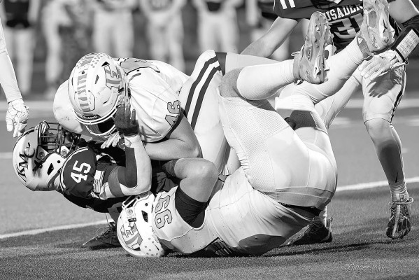 Eisenhower defenders Jameson Turner and Travis Nicholson team up to bring down Kapaun-Mt. Carmel running back Omari Elias. The Tigers fell just short of qualifying for their first-ever State football championship. Matt Bucher/Contributed photo
