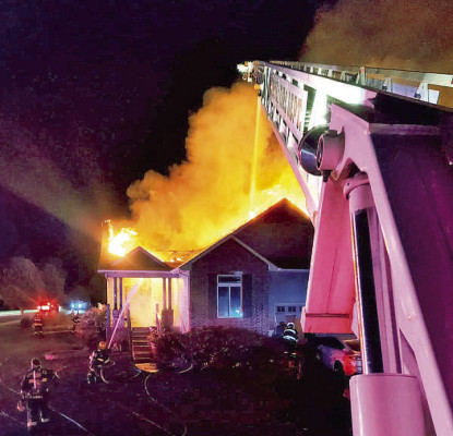 Firefighters spray water into the home of Jay and Chantel Volpe from an aerial ladder and through the front door during the early hours of Saturday. The family lost their home and several pets. Contributed photo