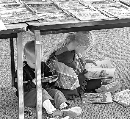 These kids found such interesting books at last year’s Goddard Fall Festival book sale that they couldn’t wait to get home to start reading. Contributed photo