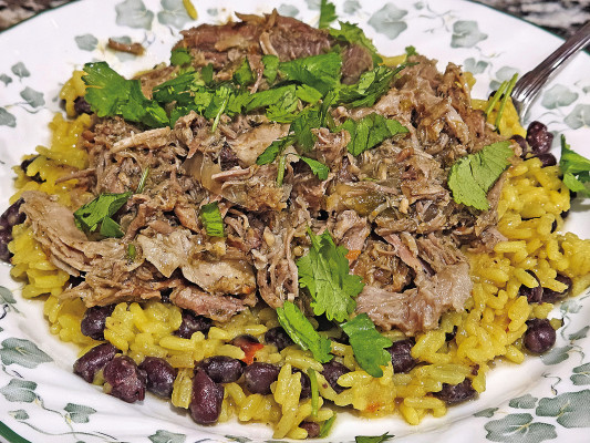 Slow cooker mojo pork has a bright flavor, thanks to plenty of fresh citrus, that makes it the perfect dinner over some yellow rice and black beans.