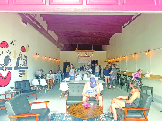 With the garage door open, a good crowd spills out of Cofellow Coffee Parlor and onto the sidewalk in downtown Goddard. The business held its grand opening and a ribbon cutting on Saturday morning. Travis Mounts/TSnews