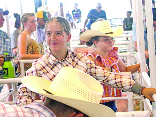 ABOVE LEFT: Violet Montes smiles as she prepares for the 4-H swine showmanship competition. She was the reserve champion in the intermediate division