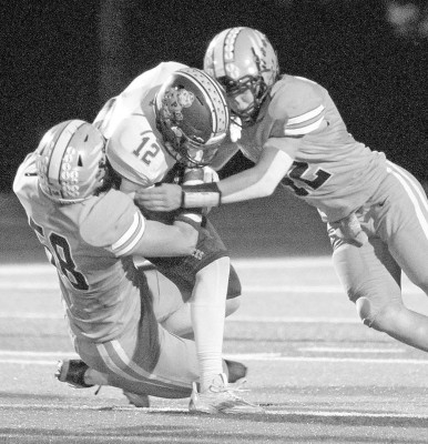 Brogan Ede, left, and Dalton Wulf team up to tackle a Pratt ball carrier in the first half of Friday’s home game. Travis Mounts/TSnews