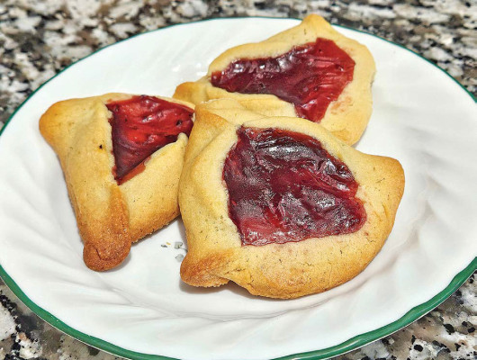Raspberry lime hamantaschen has a light flavor of lime in the cookie part of the dessert and the rich flavor of raspberry jam in the filling. A traditional treat for the Jewish celebration of Purim, its pretty red color makes for a great Christmas cookie, too.