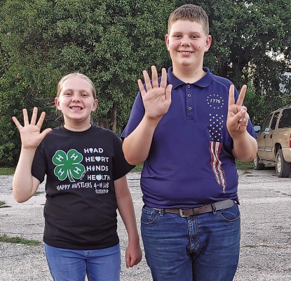 The Bradbury children – Madi, left, and Craig – show how many purple ribbons they won at the Sumner County 4-H Fair. Both are heading to the Kansas State Fair with entries that they took to the Sumner County 4-H Fair. The state fair begins next week in Hutchinson. Contributed photo