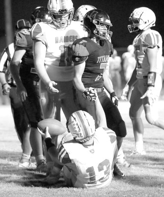Argonia-Attica Titans football player Andrew Bennett helps a Central Raider player off the turf during the teams’ recent contest. The Titans will move to 8-Man Division II football for the 2024 and 2025 seasons. They currently play in Division I.